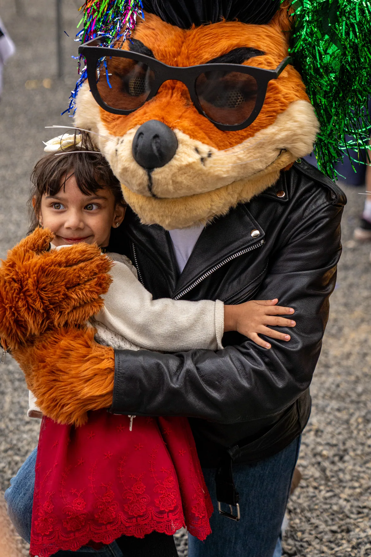 Cruiser holding a small girl on his hip, both of them facing the camera