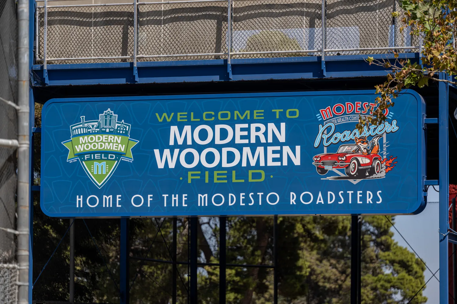 The main welcome sign under the entry canopy, the Roadsters car mark alongside the shield.