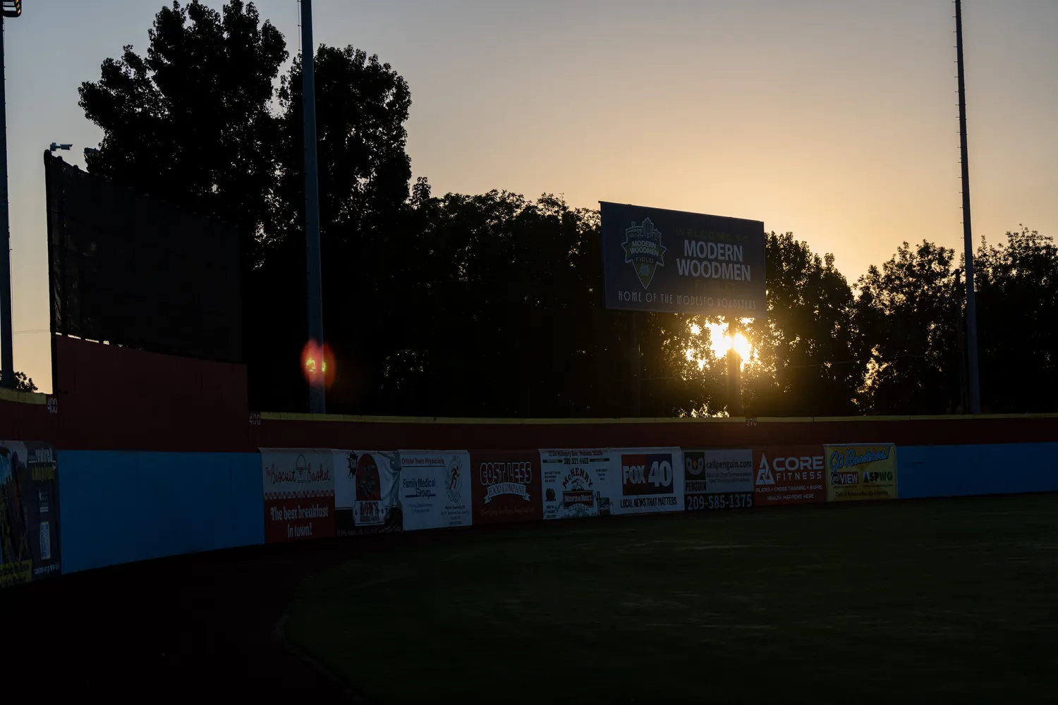 The sign in silhouette against a warm sky after sundown.